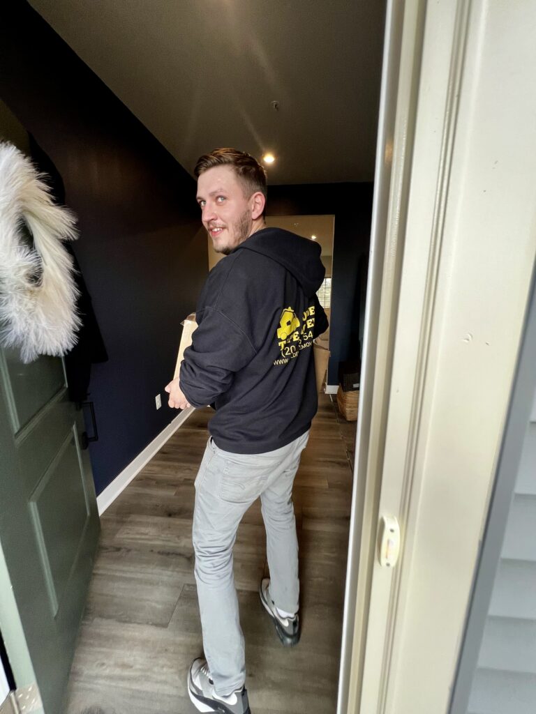 Golden Tape Movers team member carrying a box during a family relocation from Washington, DC to Raleigh, NC