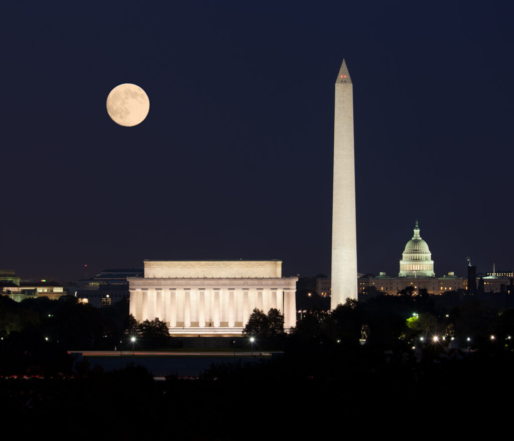 Nighttime view of Washington, DC landmarks with the Lincoln Memorial, Washington Monument, and U.S. Capitol under a full moon, representing moving out of Washington, DC with Golden Tape Movers.