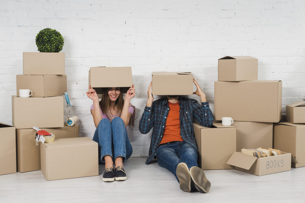 Young couple surrounded by moving boxes while packing up to move out of Washington, DC